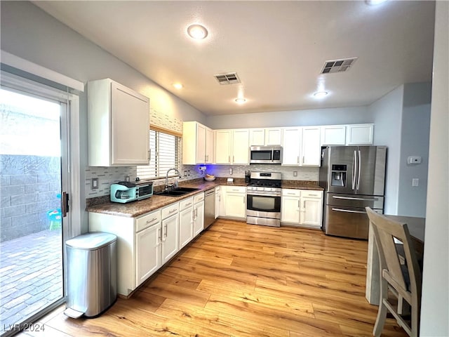 kitchen featuring appliances with stainless steel finishes, white cabinetry, and light hardwood / wood-style floors