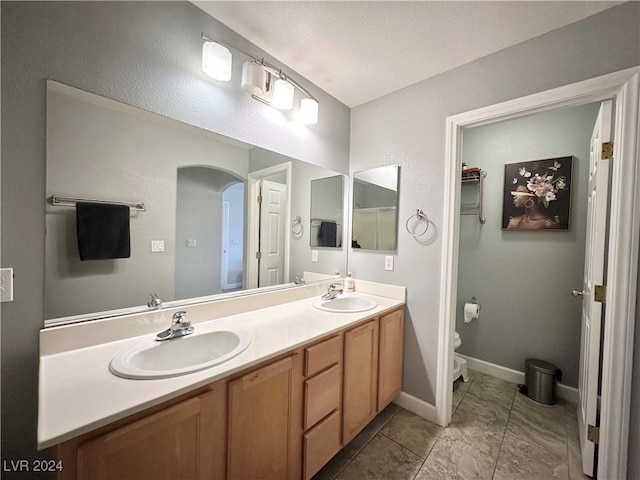 bathroom with vanity, a textured ceiling, and toilet