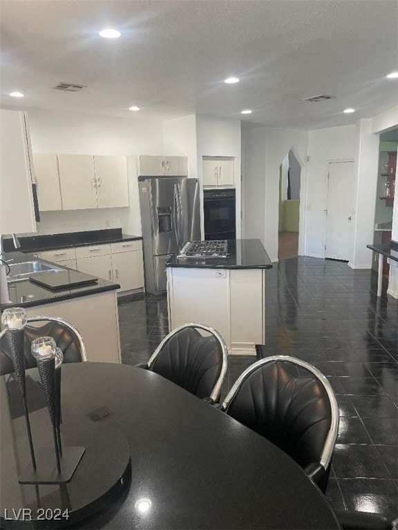 kitchen with white cabinetry, a center island, sink, and appliances with stainless steel finishes