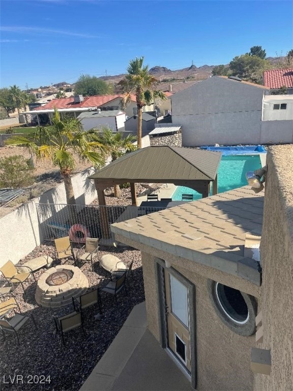 view of patio / terrace featuring a fenced in pool, a gazebo, and a fire pit