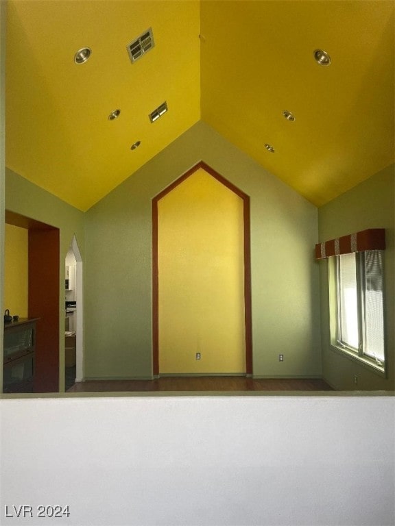 unfurnished room with vaulted ceiling