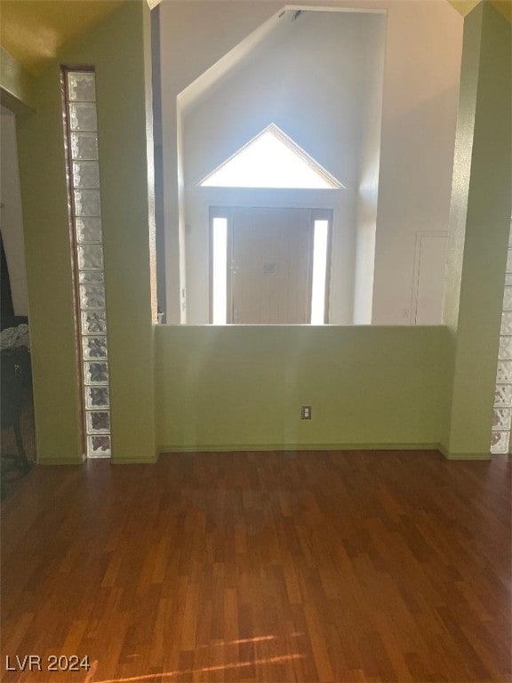 foyer entrance with dark hardwood / wood-style floors and vaulted ceiling