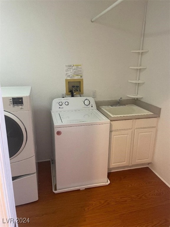 washroom with cabinets, sink, washer and dryer, and hardwood / wood-style flooring