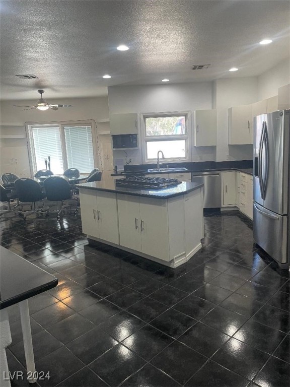 kitchen with white cabinetry, sink, ceiling fan, a textured ceiling, and appliances with stainless steel finishes