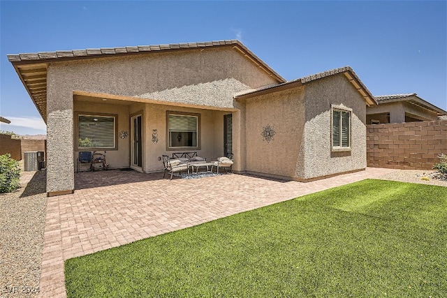 back of property featuring a patio area, a lawn, and an outdoor living space