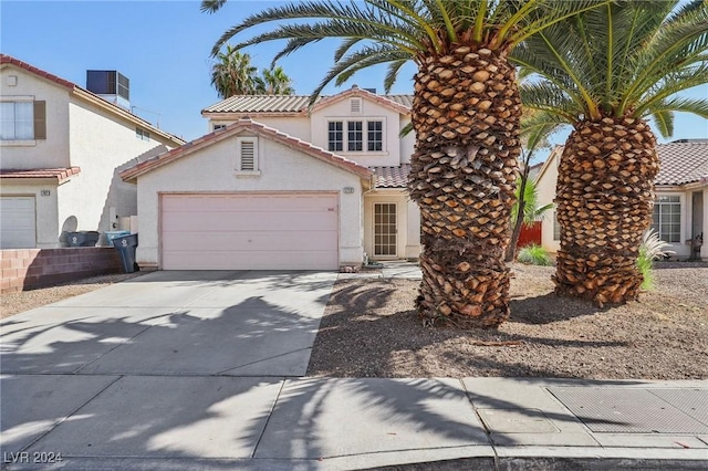 view of front of home featuring central AC unit and a garage