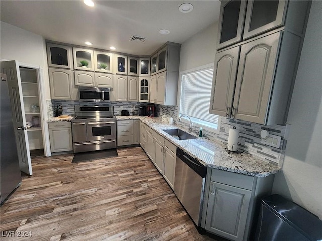 kitchen with gray cabinets, sink, dark hardwood / wood-style floors, and appliances with stainless steel finishes