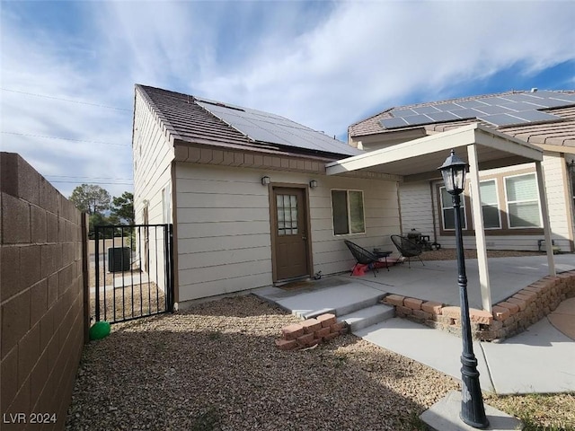 back of house with solar panels and a patio area