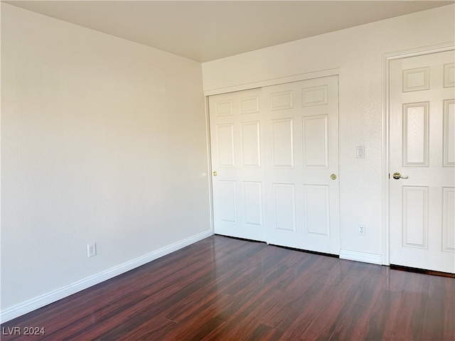 unfurnished bedroom featuring a closet and dark hardwood / wood-style floors