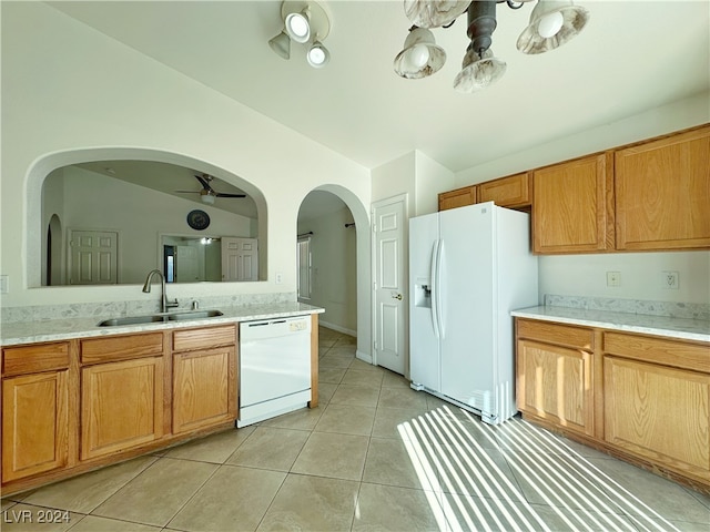 kitchen with white appliances, sink, ceiling fan, vaulted ceiling, and light tile patterned floors