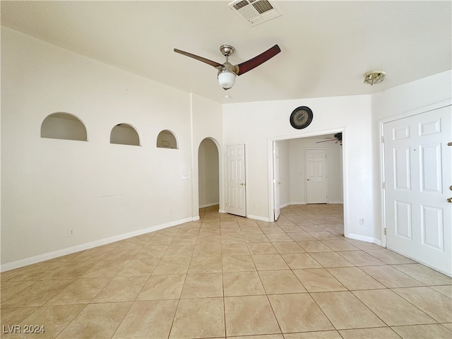 spare room with lofted ceiling, ceiling fan, and light tile patterned floors