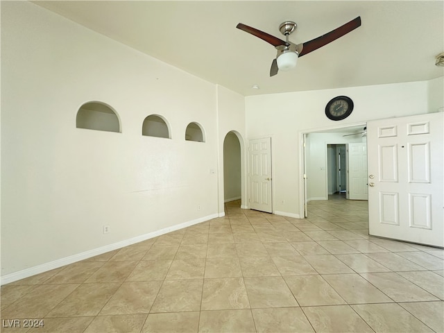 empty room with ceiling fan and light tile patterned flooring