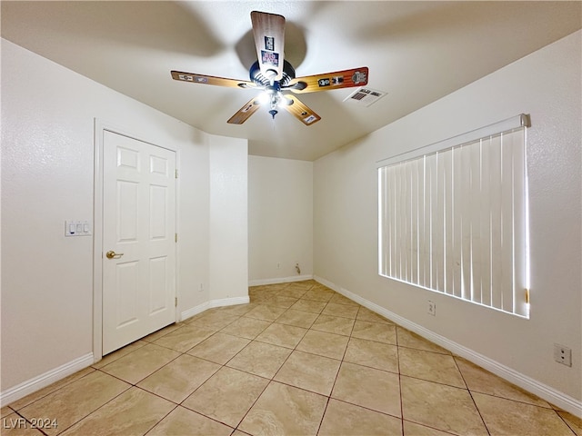 tiled spare room featuring ceiling fan