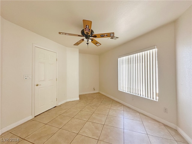 spare room with ceiling fan and light tile patterned flooring