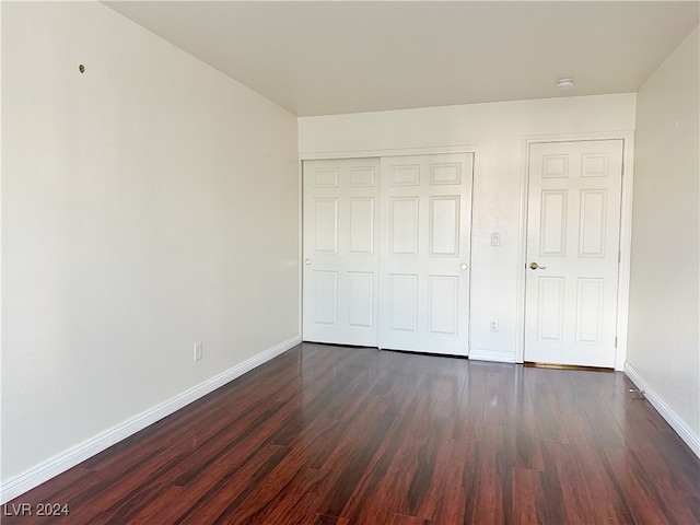 unfurnished bedroom featuring dark hardwood / wood-style floors and a closet