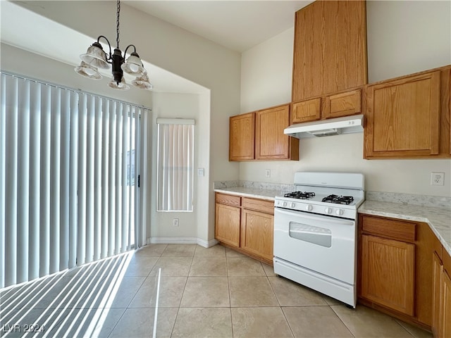 kitchen with light tile patterned flooring, an inviting chandelier, white range with gas stovetop, and hanging light fixtures