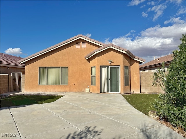 back of property with a patio and a yard