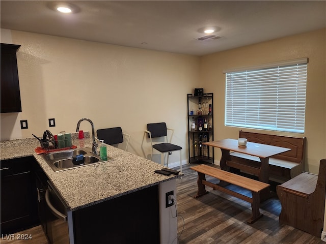 kitchen with dishwasher, dark hardwood / wood-style flooring, kitchen peninsula, and sink