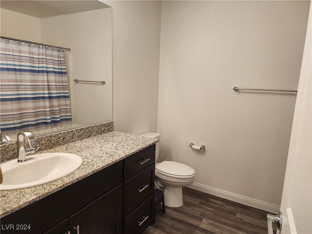 bathroom with hardwood / wood-style floors, vanity, and toilet