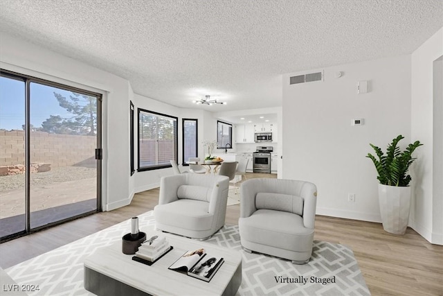 living room with light hardwood / wood-style floors and a textured ceiling