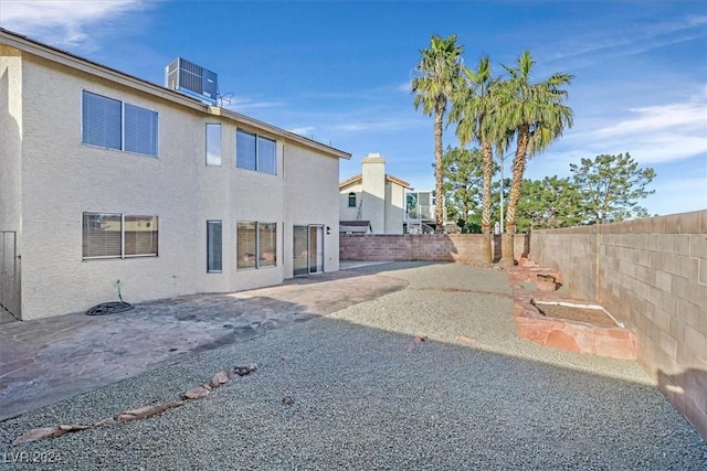 rear view of property with central air condition unit and a patio area