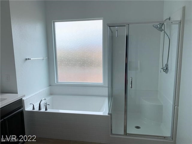 bathroom with shower with separate bathtub and vanity