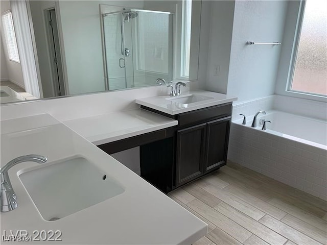 bathroom featuring vanity, hardwood / wood-style flooring, and separate shower and tub