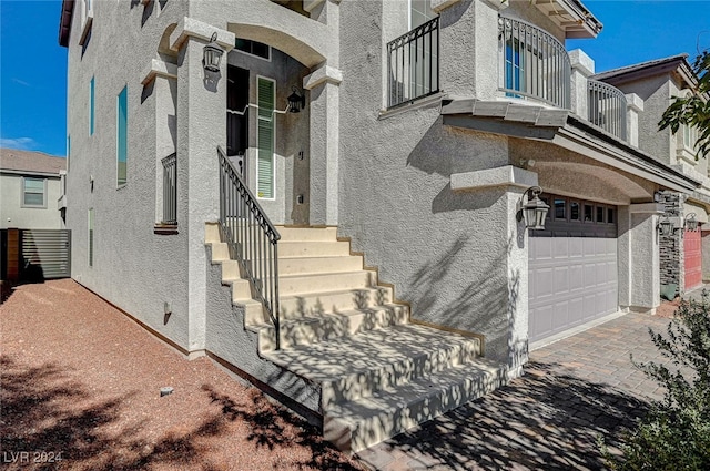 doorway to property with a balcony and a garage