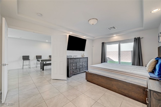 tiled bedroom featuring a raised ceiling