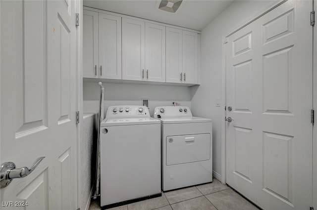 washroom featuring cabinets, independent washer and dryer, and light tile patterned floors