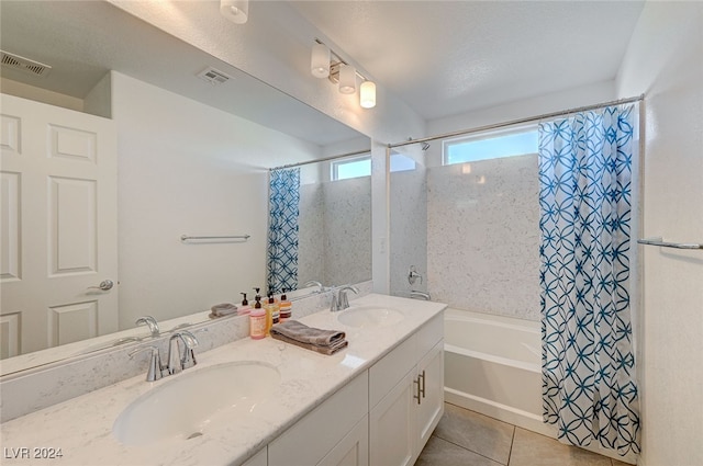 bathroom with vanity, shower / bath combo with shower curtain, a textured ceiling, and tile patterned flooring