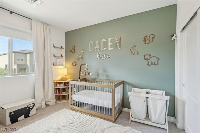 bedroom featuring a crib and carpet flooring