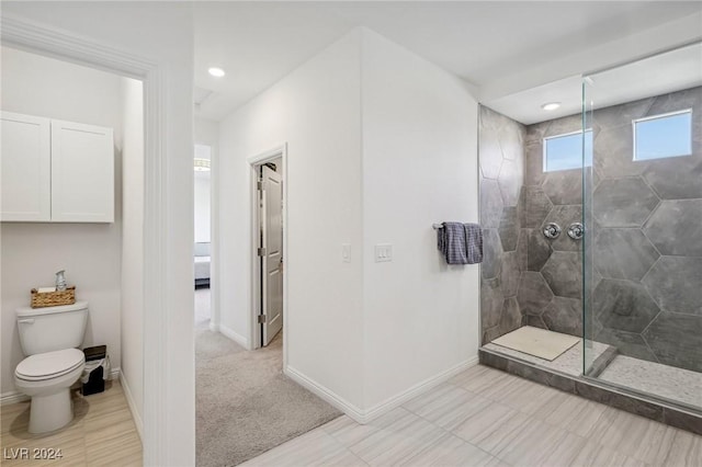 bathroom with tiled shower and toilet