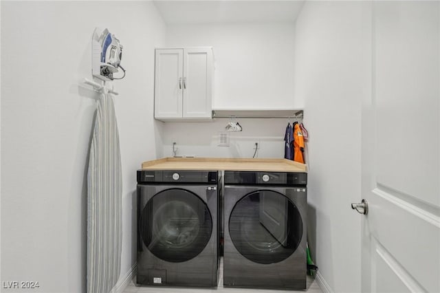 washroom with cabinets and washer and clothes dryer