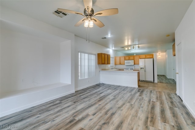 kitchen with light hardwood / wood-style flooring, kitchen peninsula, white appliances, and ceiling fan