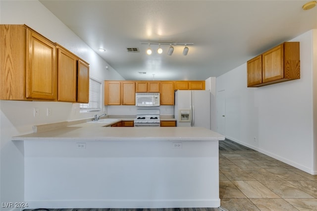 kitchen featuring kitchen peninsula, rail lighting, sink, and white appliances