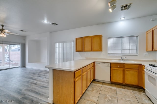 kitchen featuring white appliances, sink, light wood-type flooring, kitchen peninsula, and ceiling fan