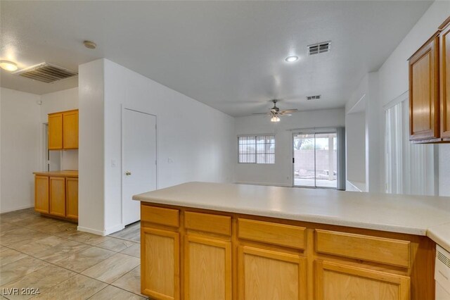 6214 Osaka Pearl St, North Las Vegas, NV 89031 - kitchen with ceiling fan, a peninsula, and light countertops