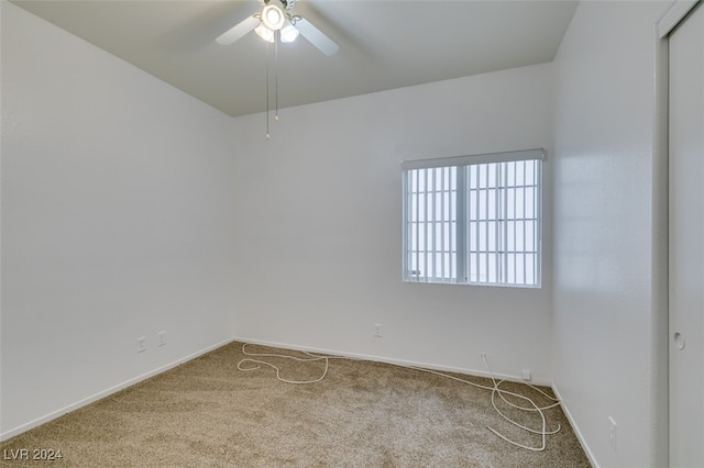 carpeted spare room with ceiling fan