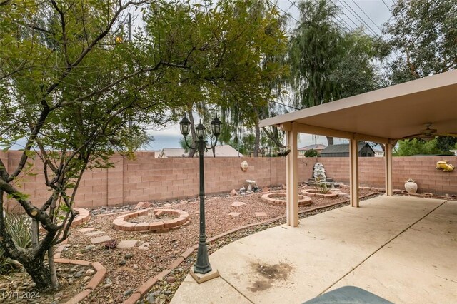 6214 Osaka Pearl St, North Las Vegas, NV 89031 - fenced backyard featuring a ceiling fan, a patio area, and an outdoor fire pit