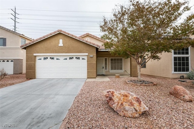 6214 Osaka Pearl St, North Las Vegas, NV 89031 - view of front of property featuring stucco siding, concrete driveway, an attached garage, and a tile roof
