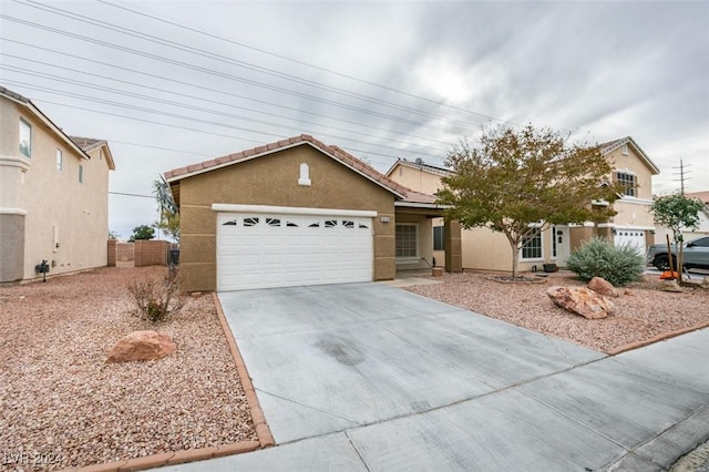 6214 Osaka Pearl St, North Las Vegas, NV 89031 - view of front facade featuring concrete driveway, stucco siding, a garage, and a tile roof