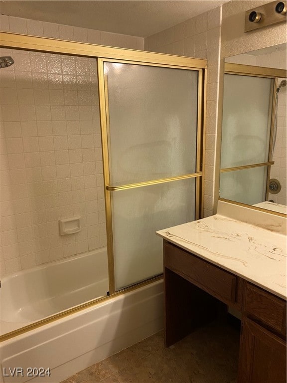 bathroom with vanity and combined bath / shower with glass door