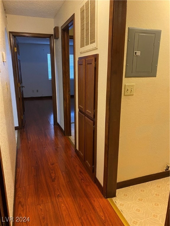 hall featuring electric panel, a textured ceiling, and dark hardwood / wood-style flooring