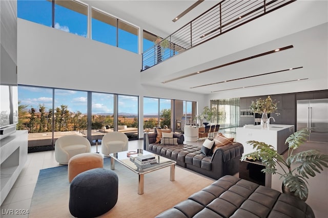 living room with a towering ceiling and light tile patterned floors