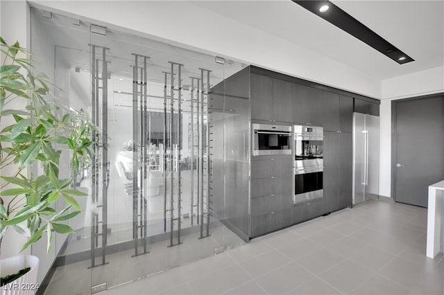 kitchen featuring double oven and light tile patterned floors