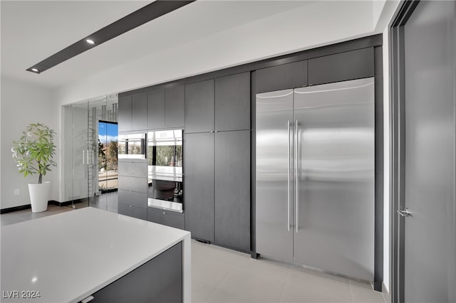 kitchen featuring built in fridge and light tile patterned floors