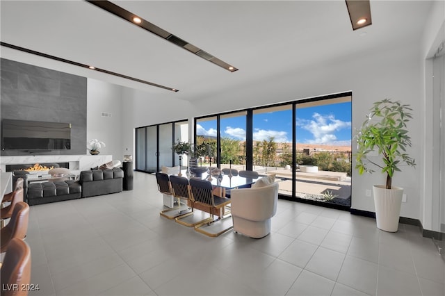 dining space featuring a fireplace and light tile patterned floors