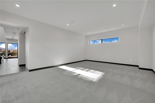 carpeted spare room featuring plenty of natural light