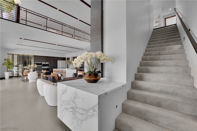 staircase featuring a towering ceiling